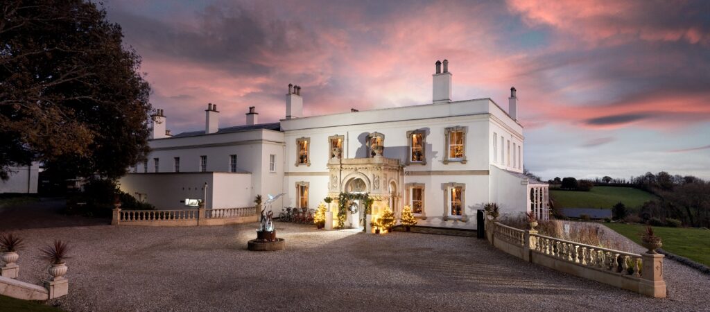 Lympstone Manor exterior in winter with pink sky at dusk