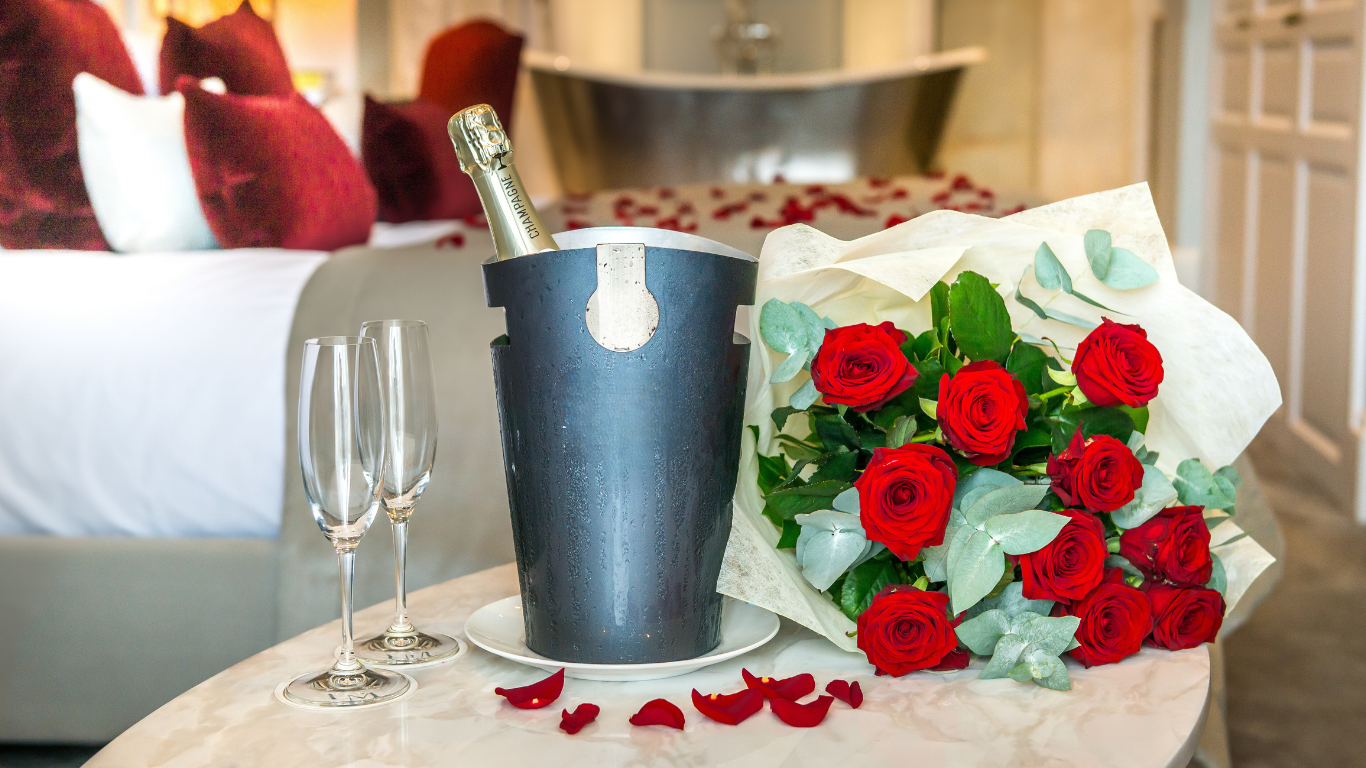 Guest room with champagne, glasses and red roses