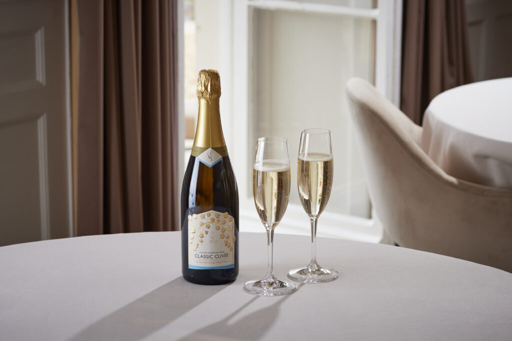 Lympstone Manor Estate Cuvee bottle with two glasses on the table in fine dining room