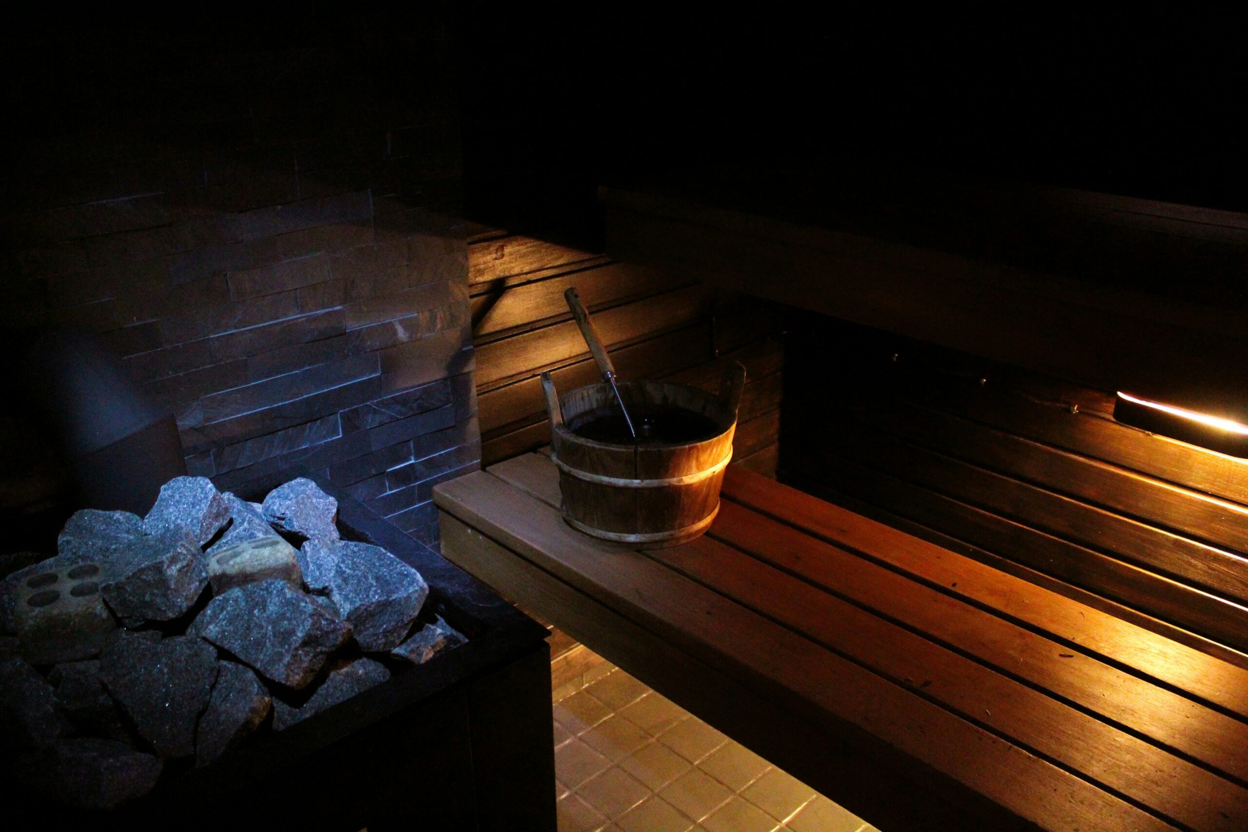 Inside a sauna with hot coals and water bucket