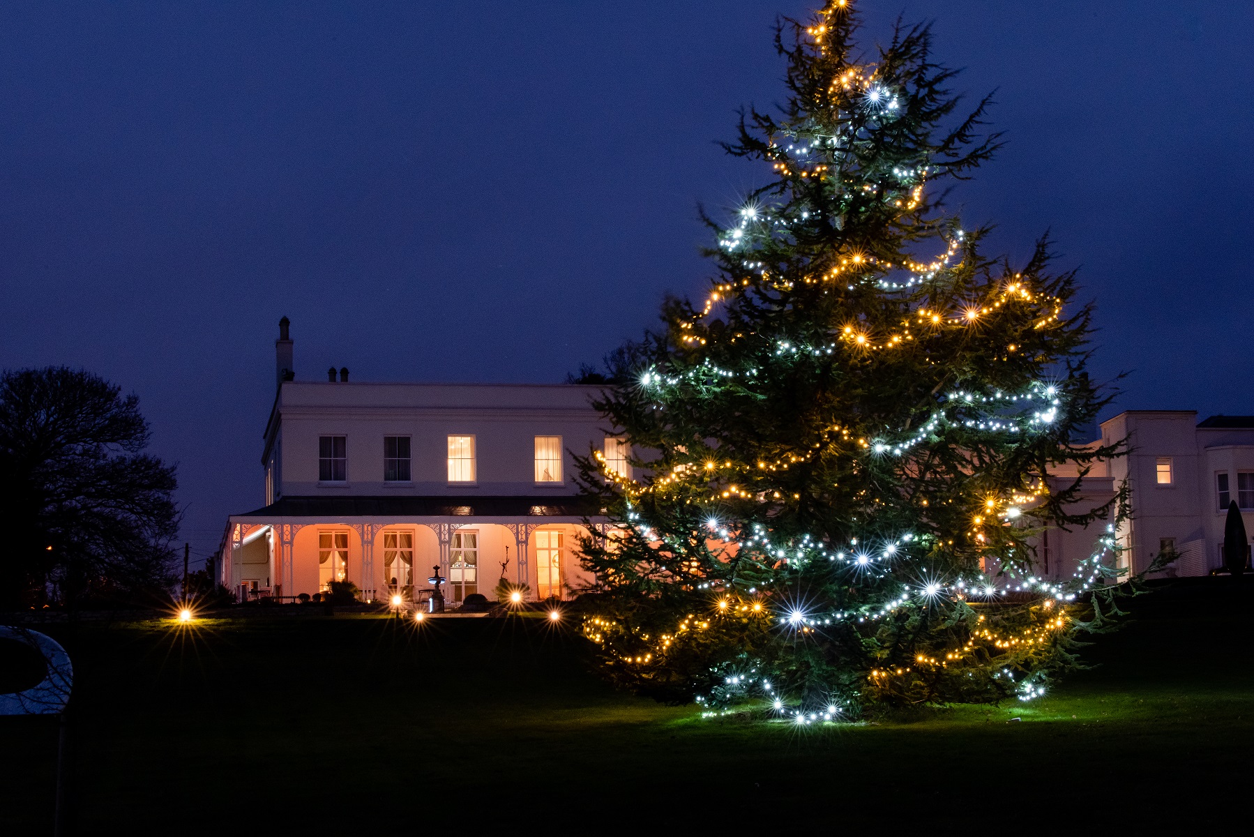 Lympstone Manor at Christmas with christmas tree in the foreground