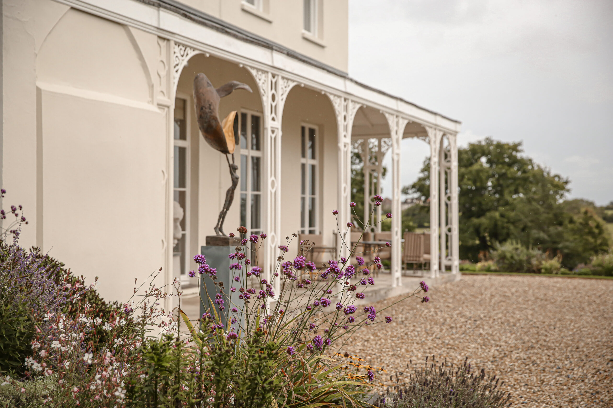 Lympstone Manor terrace with sculptures and flowers in the foreground