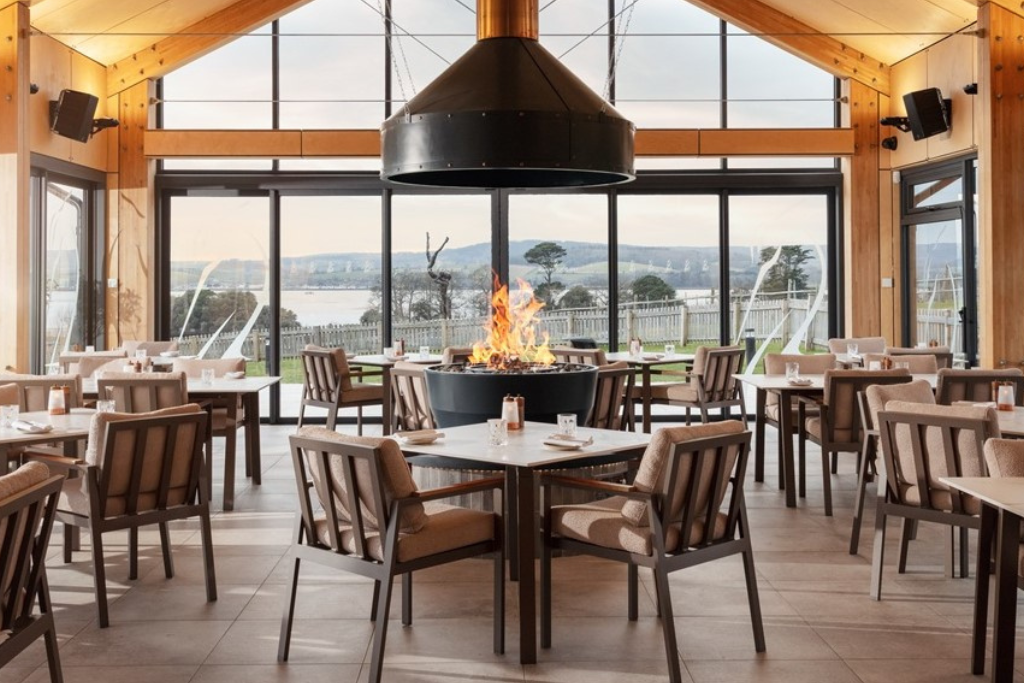 Interior of Pool House Restaurant with fire in the centre and views of the Exe Estuary